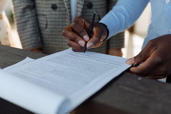Person writing on a document at a loan signing
